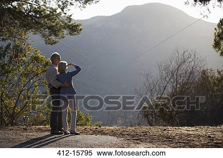 Stock Photography - Senior couple looking at mountain view. Fotosearch