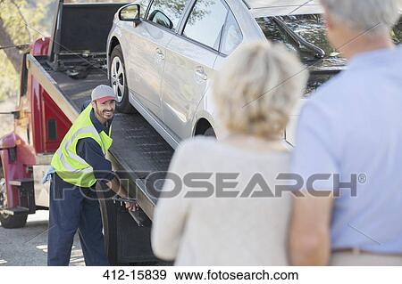 Senior couple watching roadside mechanic prepare to tow car View Large Photo Image Stock Photo - Senior couple watching roadside mechanic prepare to tow car. Fotosearch