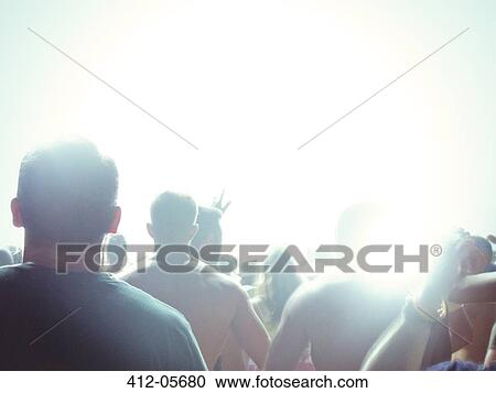 Silhouette of fans facing illuminated stage View Large Photo Image Stock Image - Silhouette of fans facing illuminated stage. Fotosearch