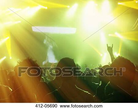 Silhouetted fans facing illuminated stage View Large Photo Image Stock Image - Silhouetted fans facing illuminated stage. Fotosearch