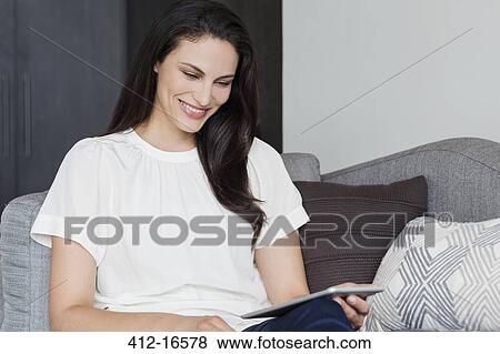 Smiling woman using digital tablet View Large Photo Image Stock Photo - Smiling woman using digital tablet. Fotosearch