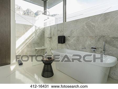 Soaking tub in sunny modern bathroom View Large Photo Image Stock Image - Soaking tub in sunny modern bathroom. Fotosearch