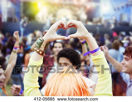 Woman forming heart-shape with hands at music festival View Large Photo Image Stock Photography - Woman forming heart-shape with hands at music festival. Fotosearch