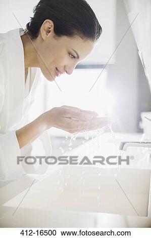Woman in bathrobe splashing water on face View Large Photo Image Stock Image - Woman in bathrobe splashing water on face. Fotosearch