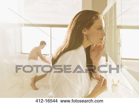 Woman looking at face in mirror View Large Photo Image Picture - Woman looking at face in mirror. Fotosearch