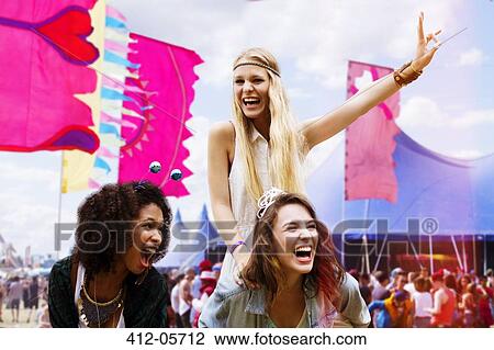Woman piggybacking enthusiastic friend at music festival View Large Photo Image Stock Image - Woman piggybacking enthusiastic friend at music festival. Fotosearch