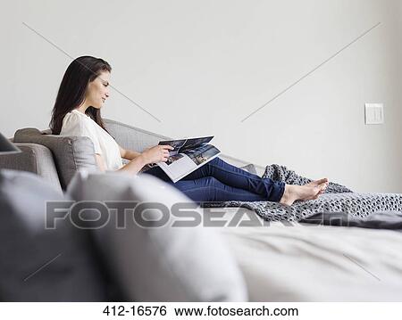 Woman reading magazine on chaise lounge View Large Photo Image Stock Photograph - Woman reading magazine on chaise lounge. Fotosearch