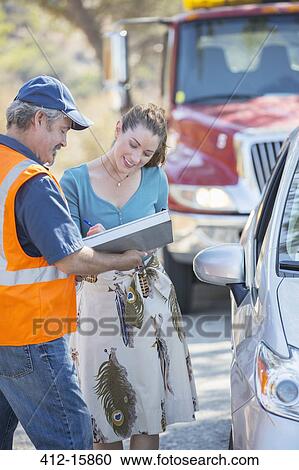 Woman signing paperwork for roadside mechanic View Large Photo Image Stock Image - Woman signing paperwork for roadside mechanic. Fotosearch
