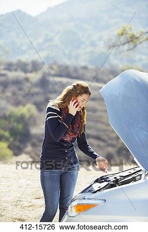 Woman talking on cell phone with automobile hood raised at roadside View Large Photo Image Stock Photograph - Woman talking on cell phone with automobile hood raised at roadside. Fotosearch