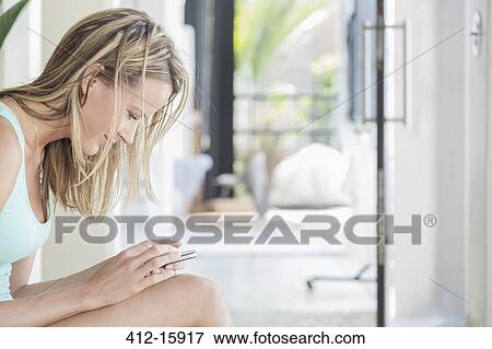 Stock Photo - Woman texting with cell phone. Fotosearch