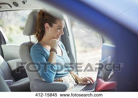Stock Photography - Woman using laptop in car. Fotosearch