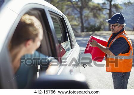 Stock Photograph - Woman watching roadside mechanic fill gas tank. Fotosearch