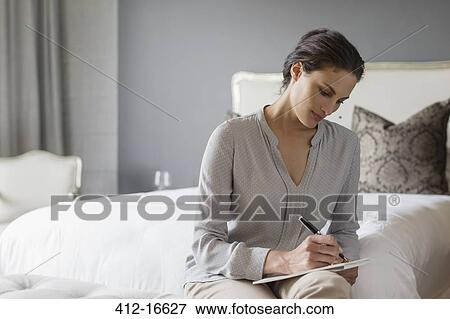 Stock Photo - Woman writing in bedroom. Fotosearch