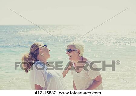 Women laughing on sunny beach View Large Photo Image Stock Image - Women laughing on sunny beach. Fotosearch