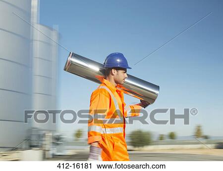 Worker carrying stainless steel tube View Large Photo Image Stock Image - Worker carrying stainless steel tube. Fotosearch