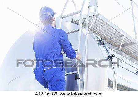 Worker climbing ladder at back of stainless steel milk tanker View Large Photo Image Stock Photo - Worker climbing ladder at back of stainless steel milk tanker. Fotosearch