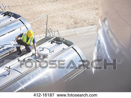 Worker on platform above stainless steel milk tanker View Large Photo Image Stock Photo - Worker on platform above stainless steel milk tanker. Fotosearch