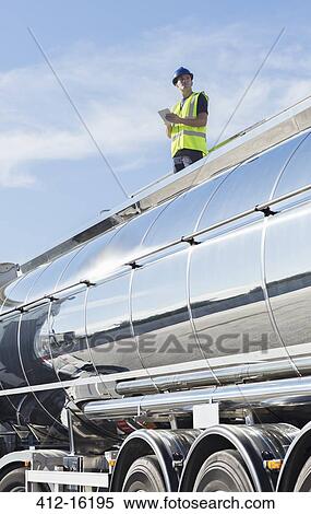 Worker using digital tablet on platform above stainless steel milk tanker View Large Photo Image Stock Photography - Worker using digital tablet on platform above stainless steel milk tanker. Fotosearch