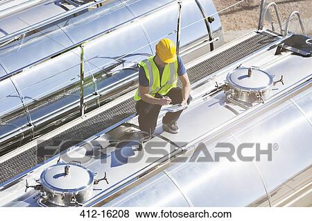 Worker using digital tablet on top of stainless steel milk tanker View Large Photo Image Stock Photo - Worker using digital tablet on top of stainless steel milk tanker. Fotosearch