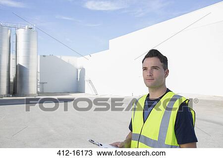 Worker with clipboard at granary View Large Photo Image Stock Image - Worker with clipboard at granary. Fotosearch