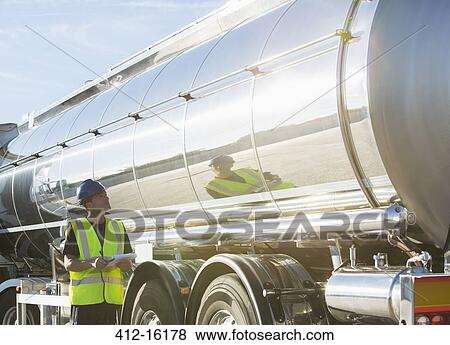 Worker with clipboard checking stainless steel milk tanker View Large Photo Image Stock Photo - Worker with clipboard checking stainless steel milk tanker. Fotosearch
