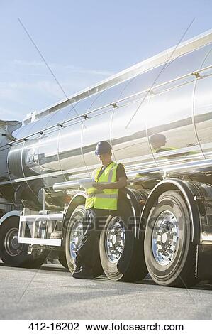 Worker with clipboard leaning on stainless steel milk tanker View Large Photo Image Stock Image - Worker with clipboard leaning on stainless steel milk tanker. Fotosearch