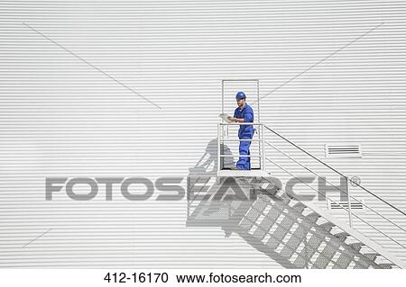 Worker with clipboard on stairs along building View Large Photo Image Stock Image - Worker with clipboard on stairs along building. Fotosearch