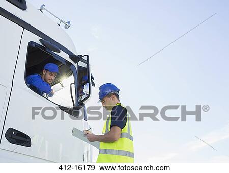 Worker with clipboard talking to truck driver View Large Photo Image Stock Photo - Worker with clipboard talking to truck driver. Fotosearch