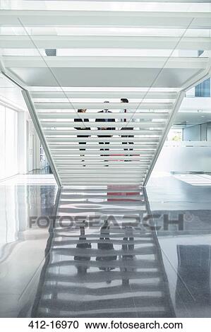 Business people ascending modern staircase in office View Large Photo Image Stock Image - Business people ascending modern staircase in office. Fotosearch