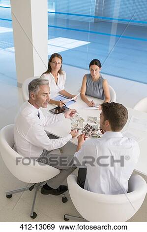 Stock Photo - Business people meeting at conference table. Fotosearch