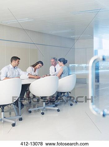 Stock Photo - Business people meeting at conference room table. Fotosearch
