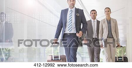 Business people pulling suitcases in corridor View Large Photo Image Stock Image - Business people pulling suitcases in corridor. Fotosearch