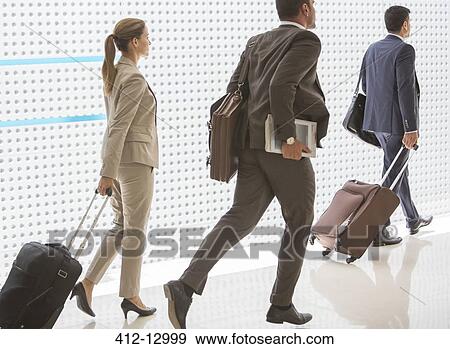 Business people pulling suitcases in corridor View Large Photo Image Stock Photo - Business people pulling suitcases in corridor. Fotosearch