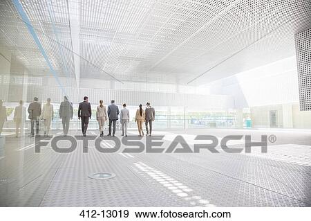 Business people walking in modern courtyard View Large Photo Image Stock Photo - Business people walking in modern courtyard. Fotosearch