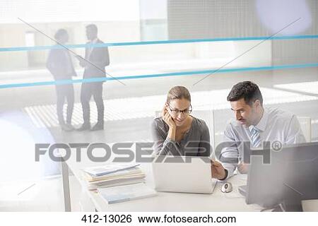 Business people working at laptop in office View Large Photo Image Stock Photograph - Business people working at laptop in office. Fotosearch