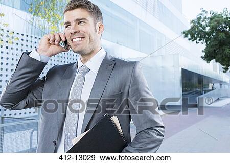 Businessman talking on cell phone outdoors View Large Photo Image Stock Photo - Businessman talking on cell phone outdoors. Fotosearch