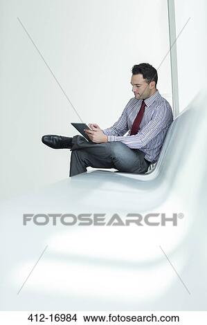 Picture - Businessman using digital tablet in lobby. Fotosearch