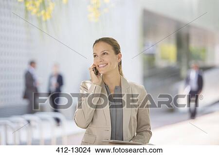 Businesswoman talking on cell phone outdoors View Large Photo Image Picture - Businesswoman talking on cell phone outdoors. Fotosearch
