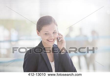 Stock Image - Businesswoman talking on cell phone. Fotosearch