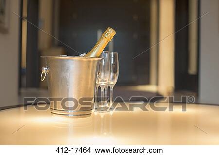 Champagne in silver bucket next to champagne flute View Large Photo Image Picture - Champagne in silver bucket next to champagne flute. Fotosearch