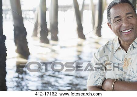 Confident senior man under pier at beach View Large Photo Image Stock Image - Confident senior man under pier at beach. Fotosearch