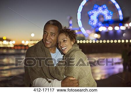 Couple hugging on beach at night View Large Photo Image Stock Photo - Couple hugging on beach at night. Fotosearch