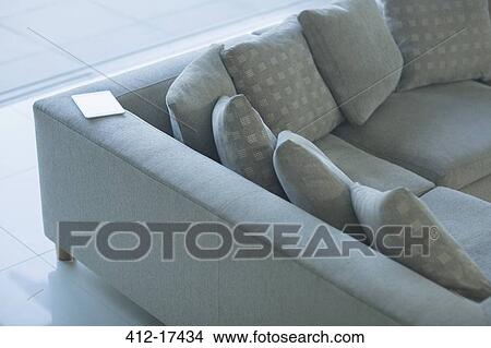 Picture - Digital tablet on sectional sofa. Fotosearch