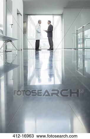 Doctor and administrator talking in hospital corridor View Large Photo Image Stock Image - Doctor and administrator talking in hospital corridor. Fotosearch