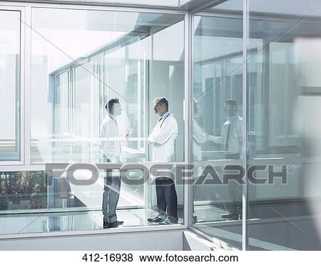Stock Photo - Doctor and administrator talking in hospital corridor. Fotosearch