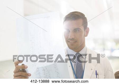 Stock Photo - Doctor examining paperwork in hospital. Fotosearch