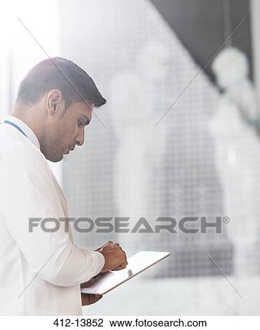 Doctor using digital tablet in hospital View Large Photo Image Stock Image - Doctor using digital tablet in hospital. Fotosearch
