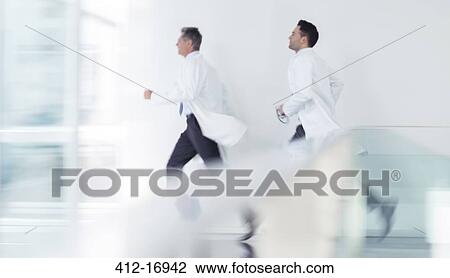 Stock Image - Doctors running in hospital corridor. Fotosearch