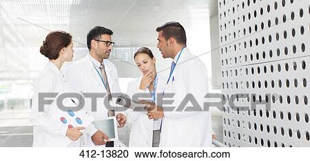 Stock Image - Doctors talking in hospital corridor. Fotosearch