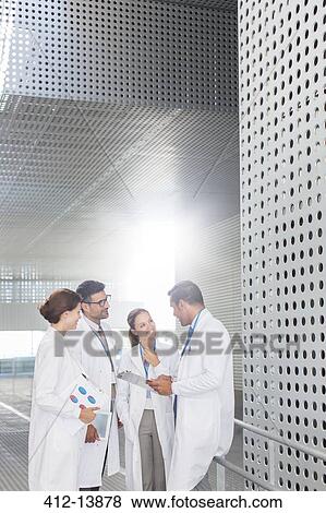 Doctors talking in hospital corridor View Large Photo Image Stock Photo - Doctors talking in hospital corridor. Fotosearch